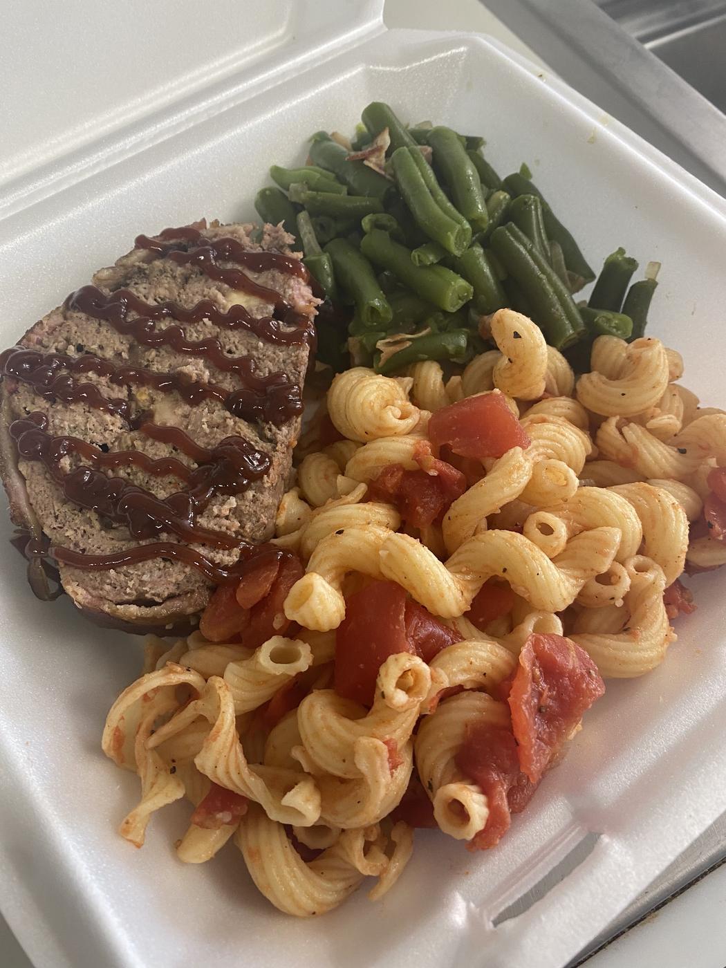 Steak, green beans and pasta packed in a takeout container
